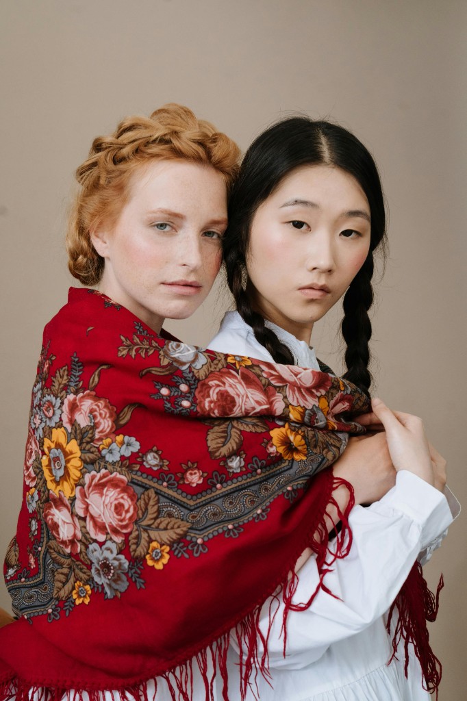 Lifestyle — two models wrapped in a floral shawl, editorial portrait